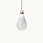 White Clérachic teardrop glass pendant on a plain white backdrop, with a tan leather strap at the neck above the frosted bowl.