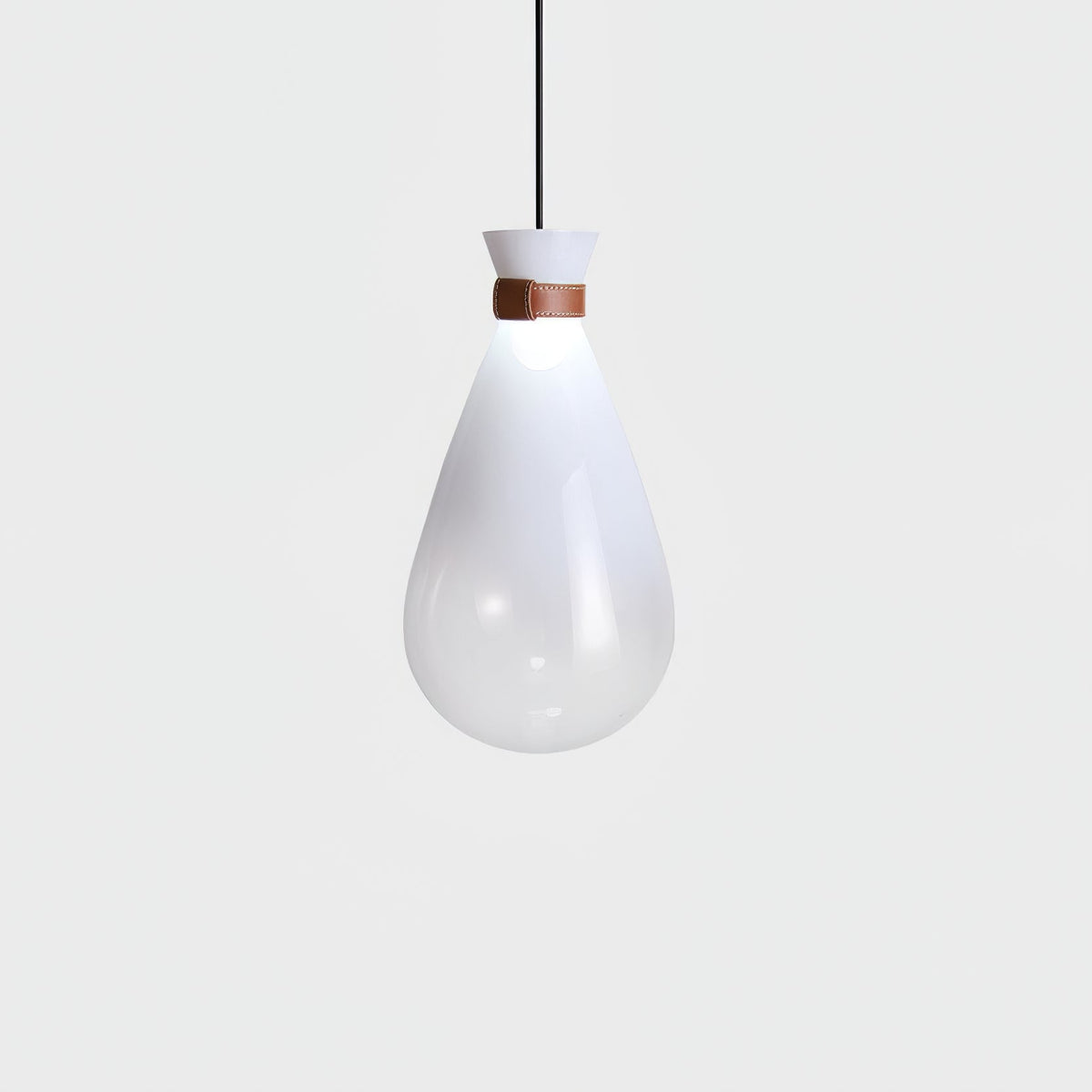 Single white Clérachic teardrop pendant with a leather strap at the neck, glowing softly against a pale grey backdrop.