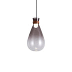 Smoke-grey Clérachic teardrop pendant on a white backdrop, fading from dark at the neck to clear at the base, with a lit bulb.