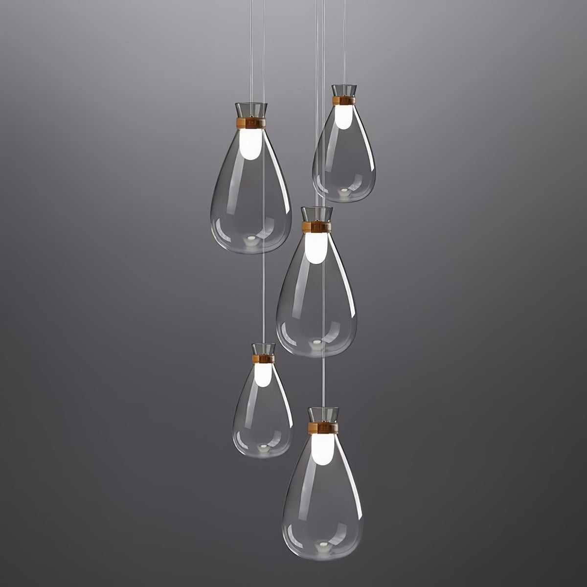 Five Clérachic teardrop pendants in clear grey-tinted glass hung at stepped heights against a dark grey backdrop.