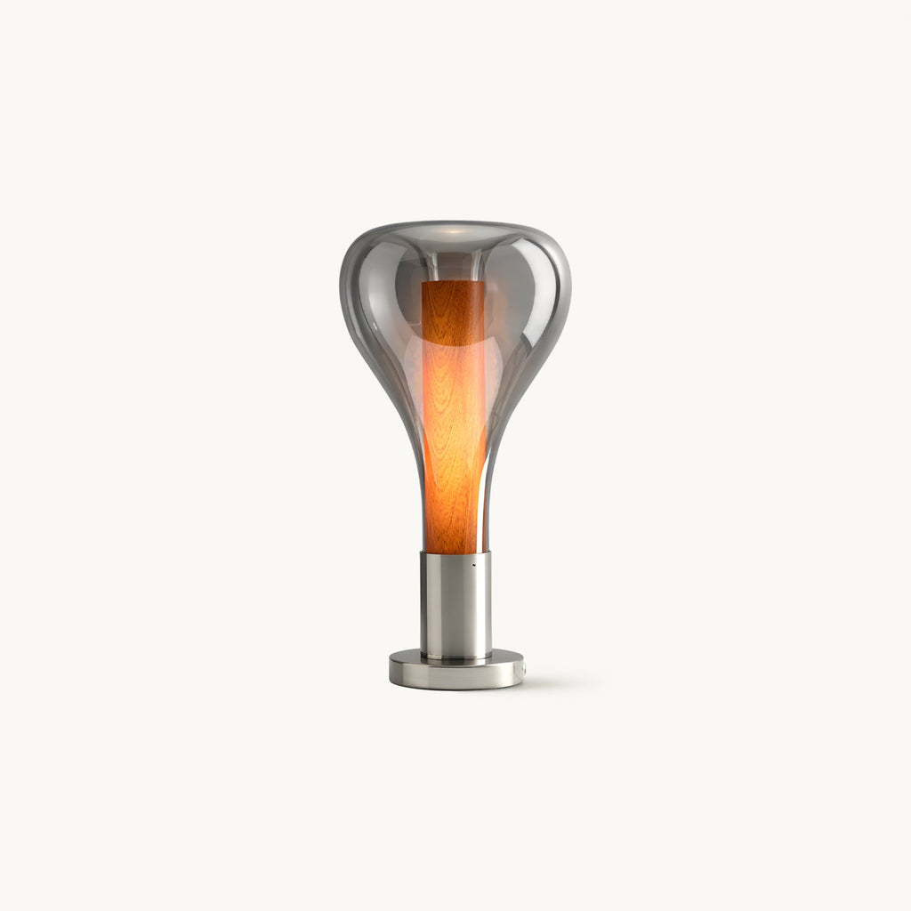 This Clérachic table lamp on a plain white backdrop: a smoke-grey glass teardrop shade around a glowing orange core, on a round chrome base.