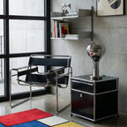 Small and mirrored, a teardrop lamp on a chrome base sits on a black steel cabinet by a window with a bold rug, from Clérachic.