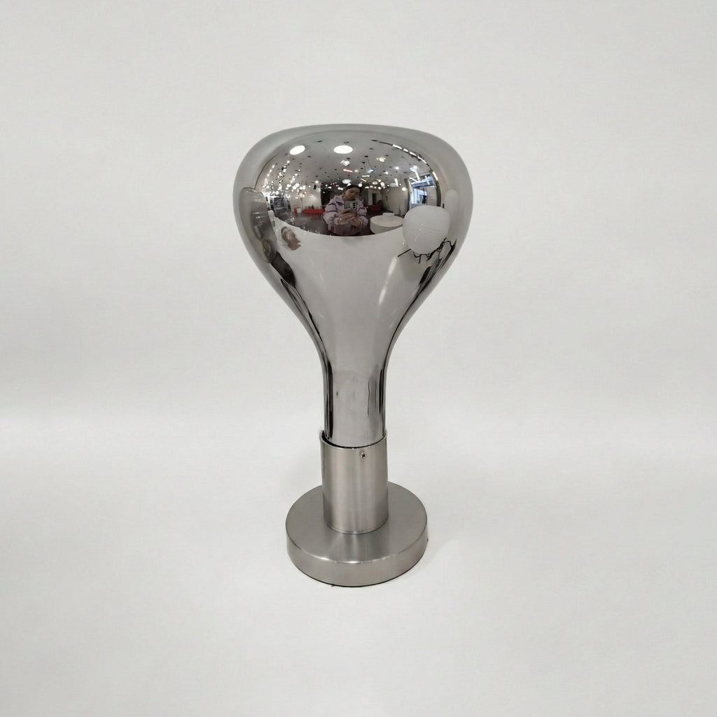 A pale grey backdrop behind this Clérachic lamp: a polished mirror-finish shade over a brushed round base, switched off.