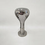 A pale grey backdrop behind this Clérachic lamp: a polished mirror-finish shade over a brushed round base, switched off.