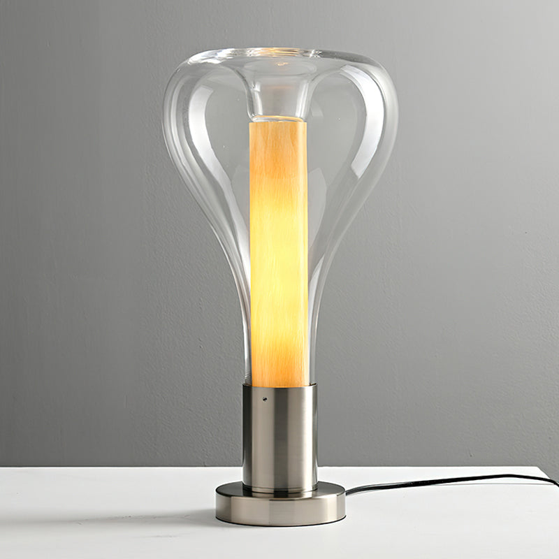 Slightly tinted clear glass surrounds a lit pale-amber core on this Clérachic lamp, on a round brushed-metal base.