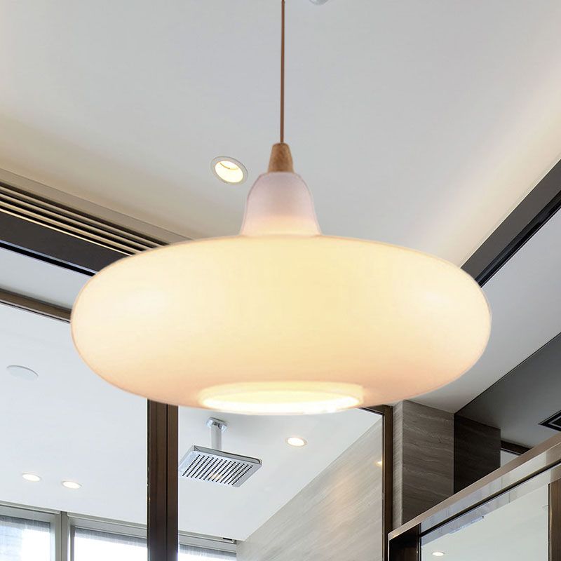 Clérachic saucer pendant in white opal glass, its wide shade spreading soft light across a bright modern room.