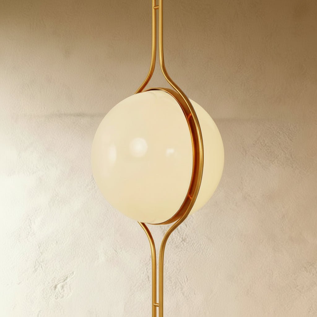 Clérachic floor-to-ceiling lamp in brass, a three-quarter view of the opal globe with the polished ring closing over its join.