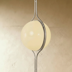 Clérachic floor-to-ceiling lamp in silver, angled to show the two opal halves meeting inside the ring.