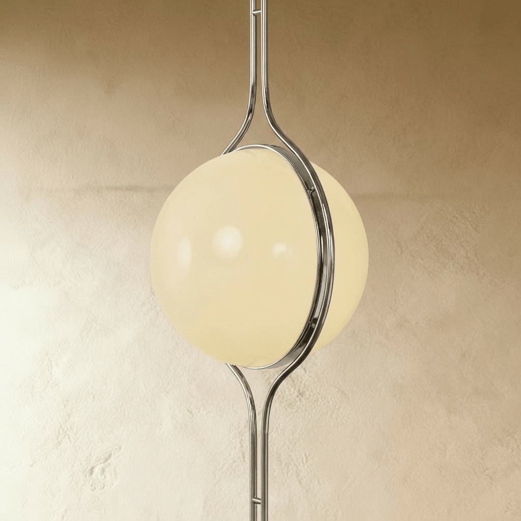 Clérachic floor-to-ceiling lamp in silver, an oblique view against pale plaster, the ring reading as a band across the lit globe.