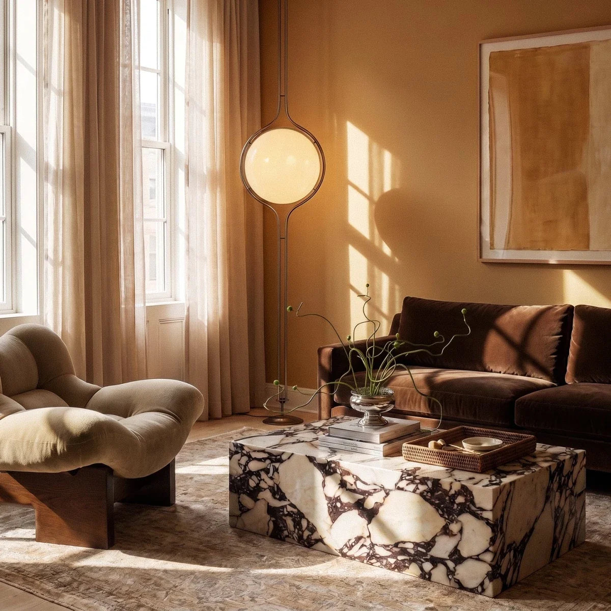 Clérachic floor-to-ceiling lamp lit in a sunlit living room, standing beside a curved lounge chair and a veined marble coffee table.