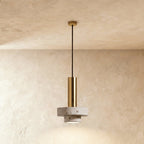 Clérachic compact pendant with a gold-toned cylinder above two stacked pale terrazzo discs, hung on a gold-toned rod from the ceiling.