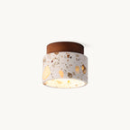 Walnut-coloured wood canopy above a cream terrazzo drum shade on this Clérachic ceiling light, shown lit against a plain white backdrop.