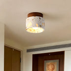 Flush-mounted Clérachic ceiling light with a terrazzo shade glowing warmly in a hallway with timber doors and a ceiling vent.