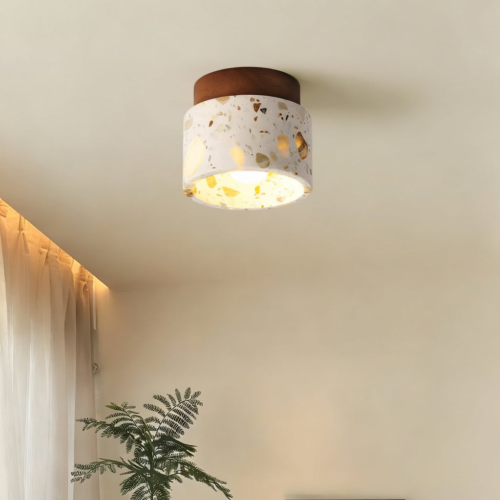 Close to the ceiling beside a sheer curtain, this Clérachic terrazzo light gives off a soft golden glow from its walnut canopy.