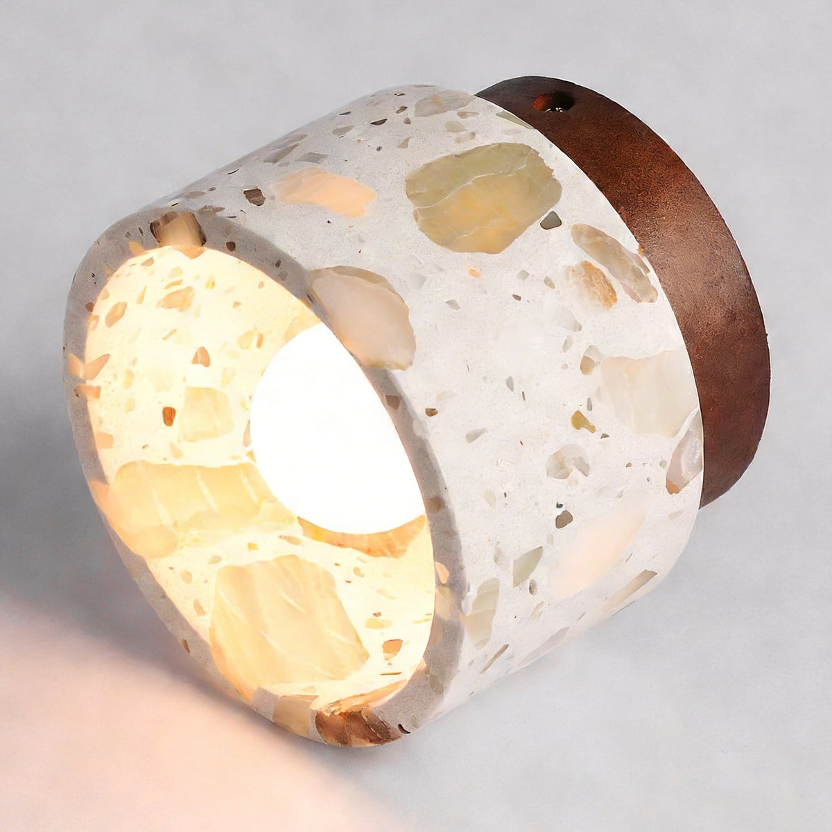 Angled close view into the terrazzo shade of this Clérachic ceiling light, showing the bulb and the walnut-coloured canopy ring.