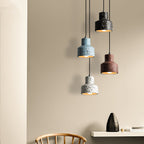 Another view of this Clérachic pendant group beside a sand wall and a shelf, blue, black, red and white shades hanging at staggered heights.