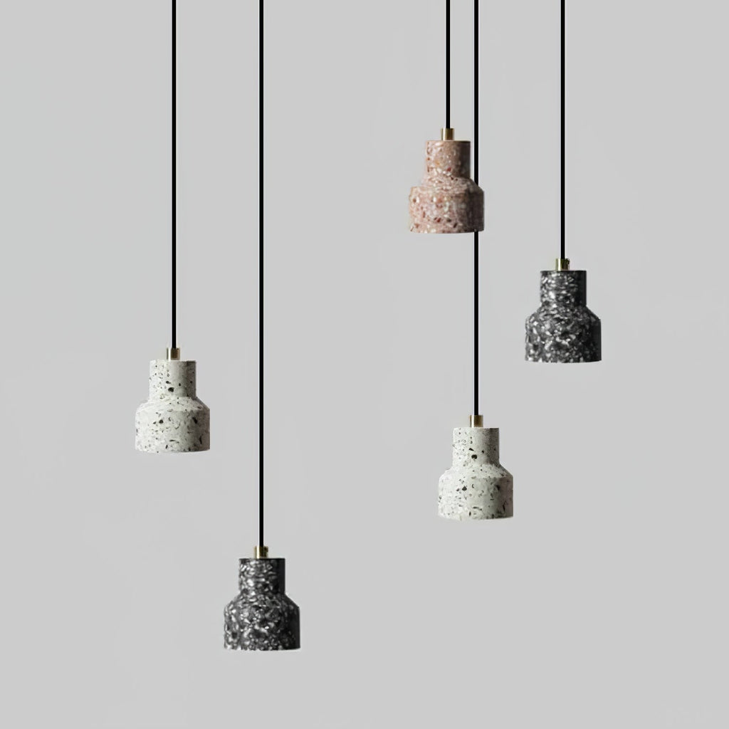 Five of these Clérachic pendants hang at staggered heights on black cords, their speckled shades in white, rose and charcoal.