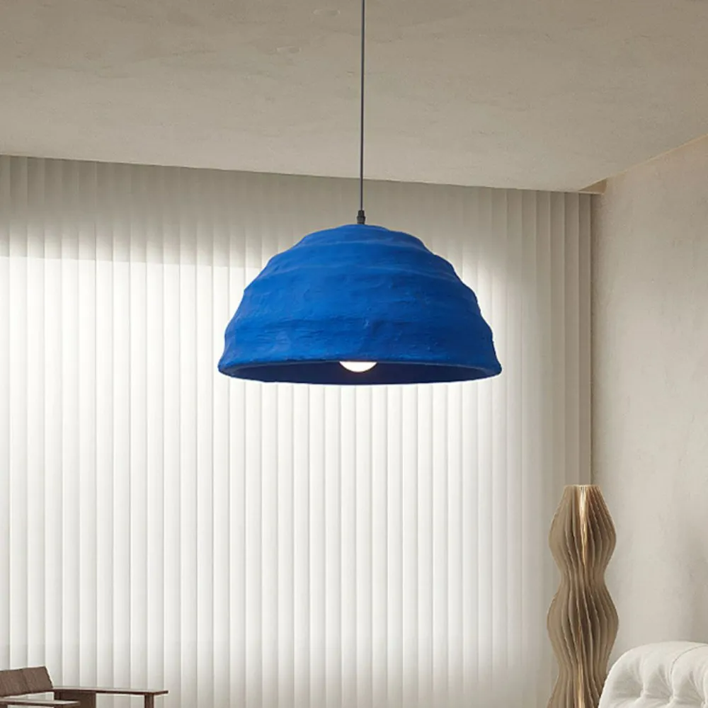 The Clérachic Textured Blue Dome Pendant Light lit beside floor-to-ceiling vertical blinds in a soft, neutral sitting room.