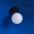 Looking up inside the Clérachic Textured Blue Dome Pendant Light at its black socket and white globe bulb against the blue interior.