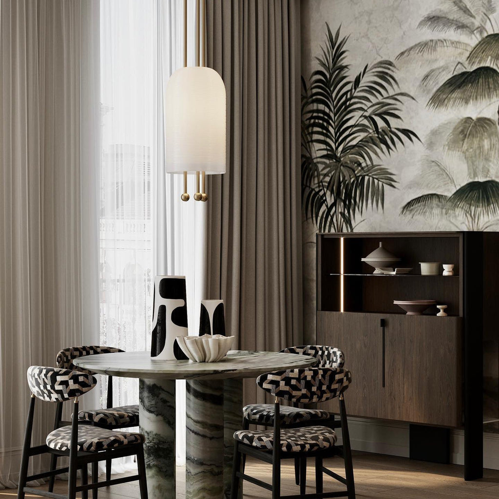 A Clérachic pendant with a smooth white shade above a round green-marble table, with patterned chairs and a palm-print wall.