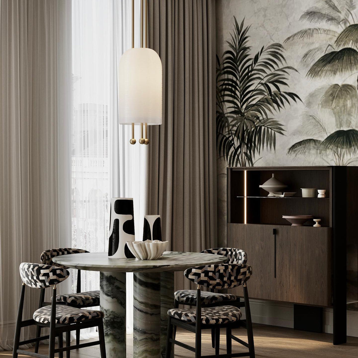 A Clérachic pendant with a smooth white shade above a round green-marble table, with patterned chairs and a palm-print wall.