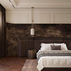 A Clérachic pendant hung low beside a dark upholstered bed, in a room with white wall panelling and a forest-print mural.