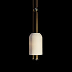 A single Clérachic ribbed white pendant on a black backdrop, lit from within, with two brass rods and balls below the shade.