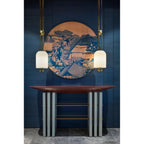 Two Clérachic pendants at different heights in front of a round blue artwork, above a console with a red top and grey legs.