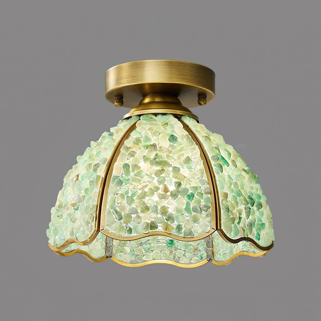 Green chipped-glass shade on this Clérachic ceiling light, with thin brass ribs and a wavy gold-edged hem against a grey backdrop.