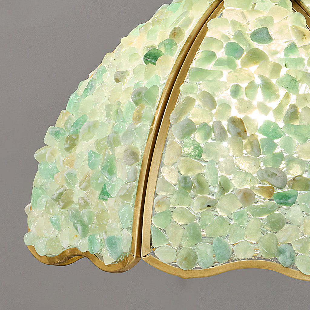Close view of the green glass chips and brass rib on the shade of this Clérachic ceiling light, lit from inside.