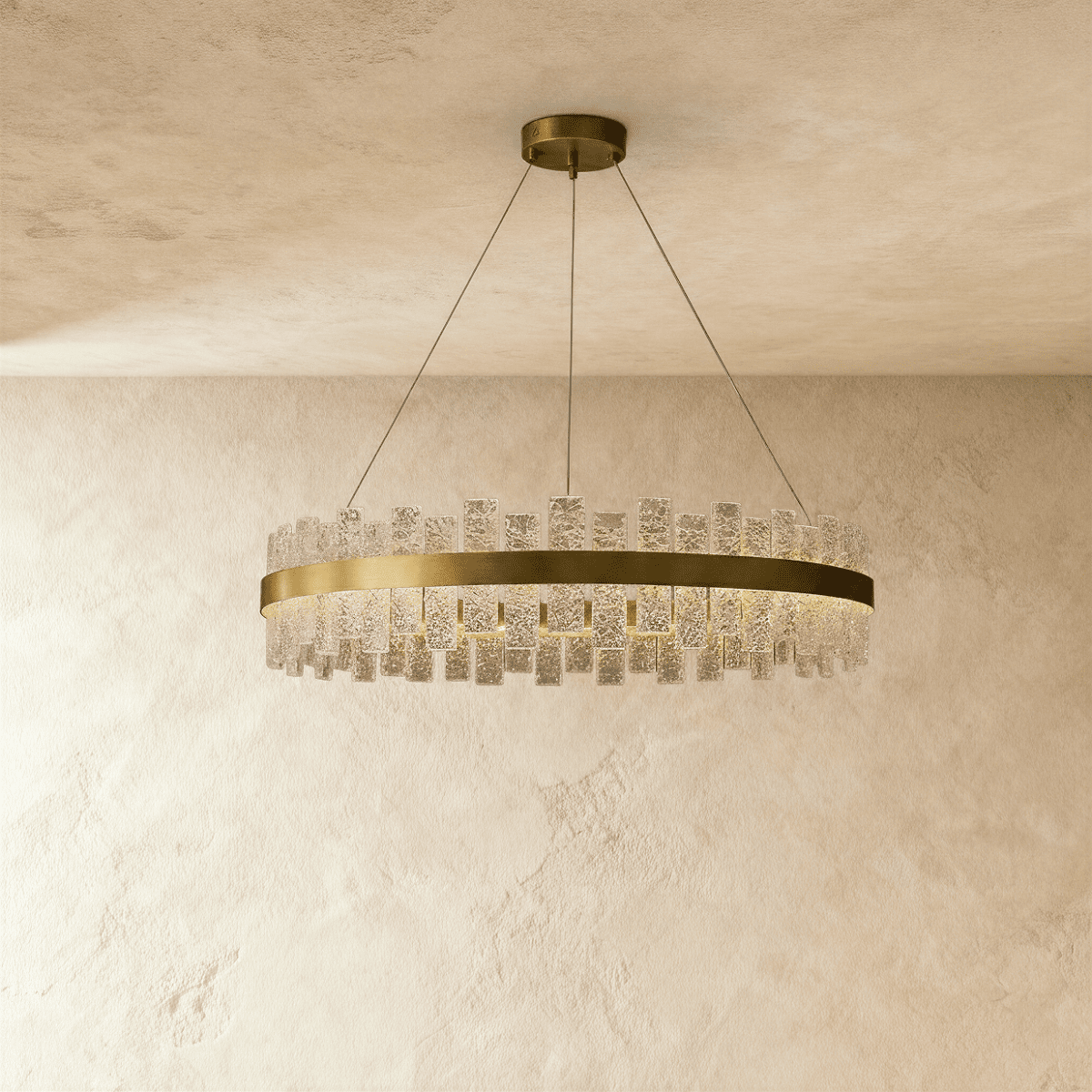 Clérachic round chandelier with a brushed brass ring and staggered textured glass panes, hung on slim cables from a ceiling plate.