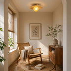 This Clérachic ceiling light with a bamboo disc and yellow globe lights a sunny reading corner with a rattan chair and books.