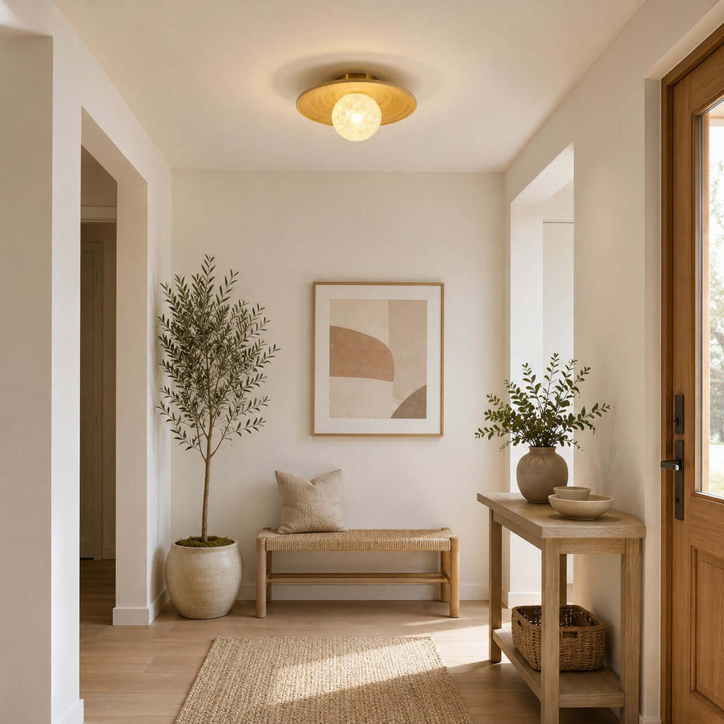 This Clérachic ceiling light in bamboo and glass lights an entry with an olive tree in a pot, a bench and a framed print.