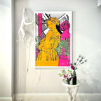 Far above a console table with a vase of flowers, a white Clérachic monkey wall light hangs beside a bold pink-and-yellow print.