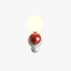 Product shot of the Clérachic three-sphere wall light in red on a plain white background, showing all three stacked spheres.