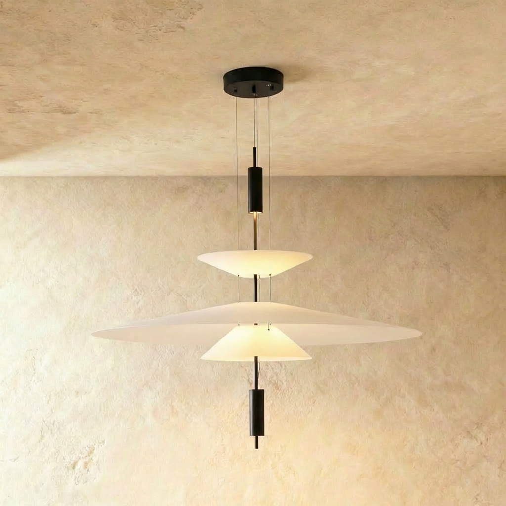 Clérachic layered pendant with a wide white frosted shade above a smaller cone, on black fittings, against limewash.