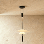 Clérachic pendant with a white frosted disc shade over a small glowing cone, suspended on fine wires from a black canopy.
