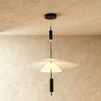 Clérachic three-layer pendant light with a broad white shade, a small cone and black rod accents, on limewash.
