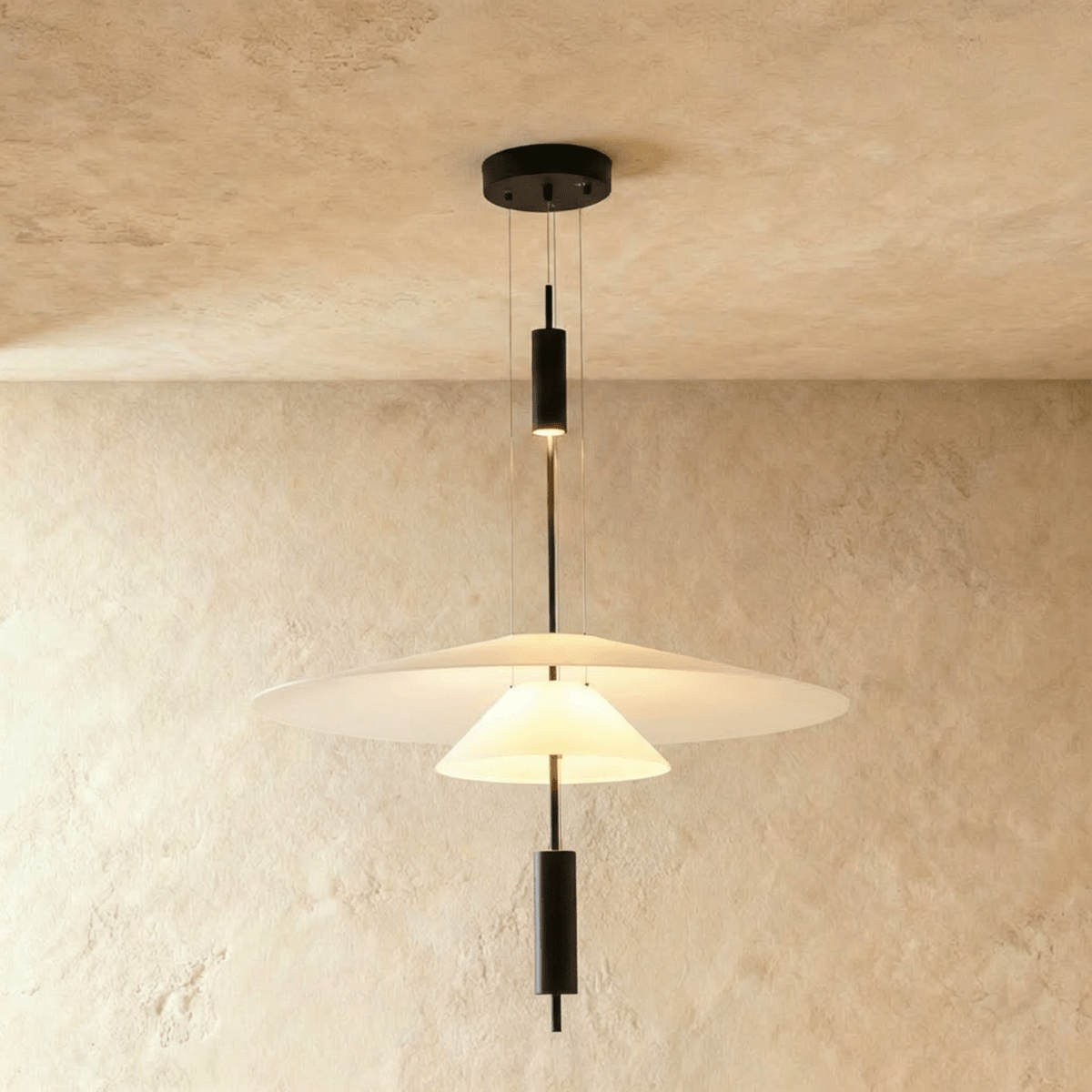 Clérachic three-layer pendant light with a broad white shade, a small cone and black rod accents, on limewash.