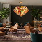 This Clérachic agate chandelier glows in a lounge with tan leather armchairs, a patterned rug and tall green plants.
