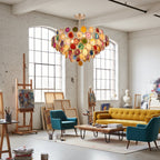 A Clérachic agate chandelier in a bright loft studio with arched windows, easels and a mustard sofa.