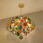 Looking up at this Clérachic agate chandelier, with a green agate slice hanging at the tip and warm light on the ceiling.