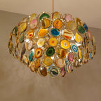 Close view of the stone slices and gold rings on this Clérachic agate chandelier, lit from within.