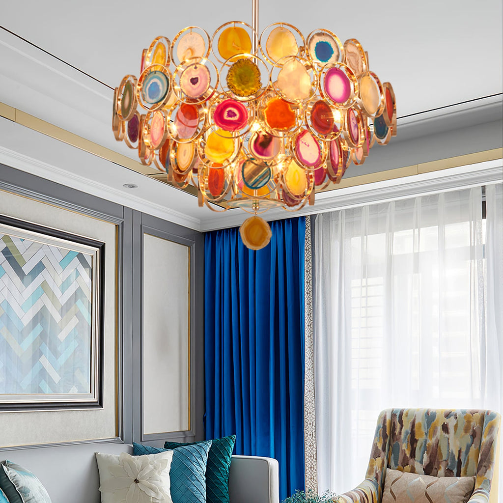 Clérachic agate chandelier in a room with blue curtains and a patterned armchair, hung under a moulded ceiling.