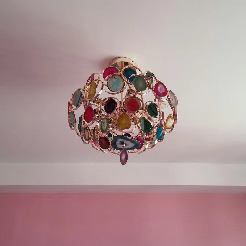 Customer-style view up at a smaller Clérachic agate chandelier on a pale ceiling, with a pink wall below.