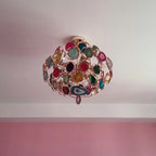 Customer-style view up at a smaller Clérachic agate chandelier on a pale ceiling, with a pink wall below.