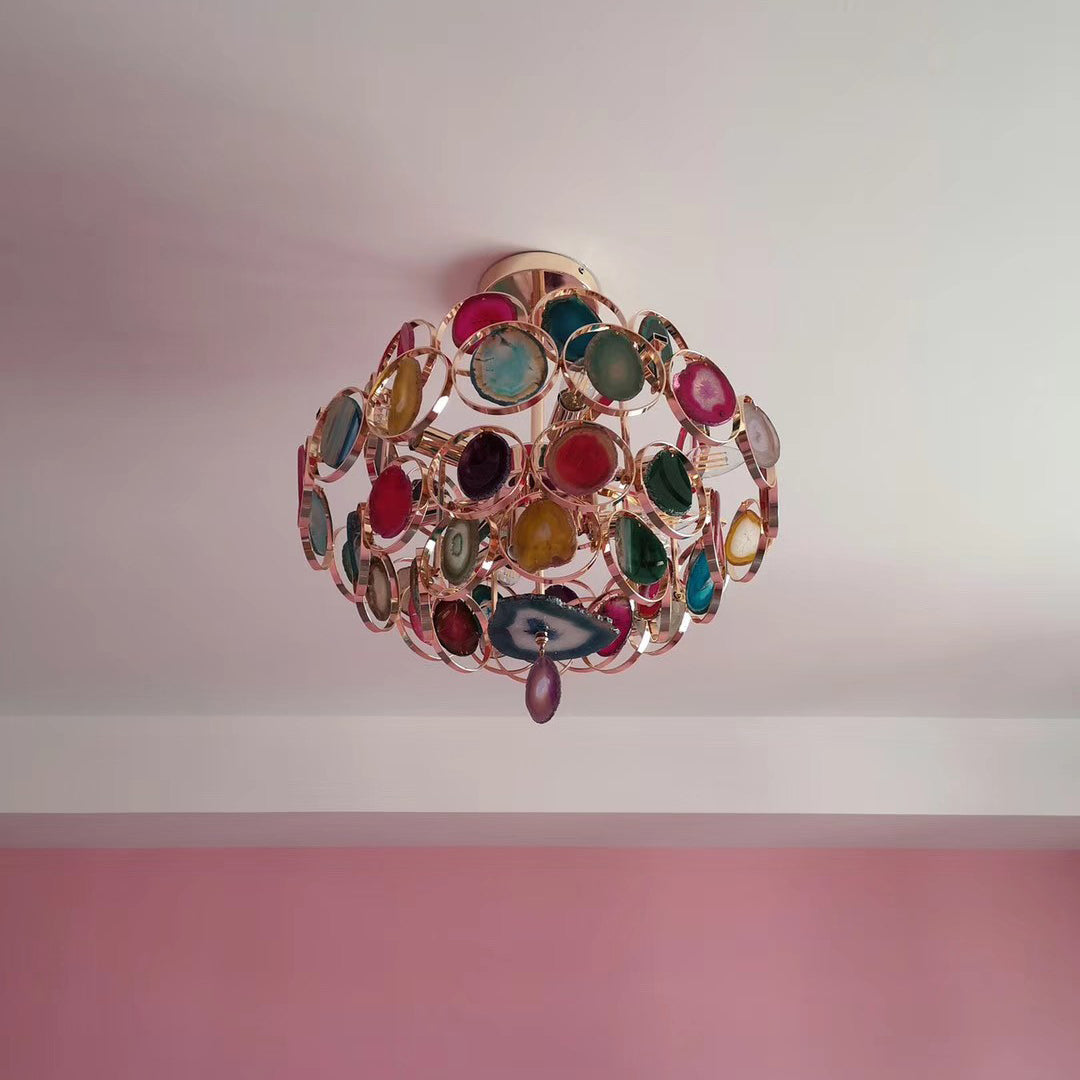 Customer-style view up at a smaller Clérachic agate chandelier on a pale ceiling, with a pink wall below.