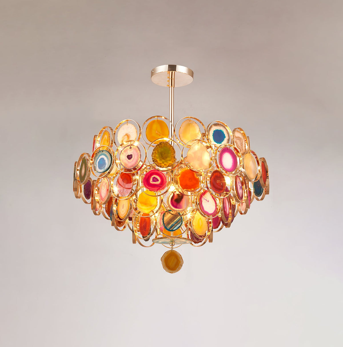 Slightly smaller view of this Clérachic agate chandelier on a soft grey wall, showing the rod and one hanging slice.