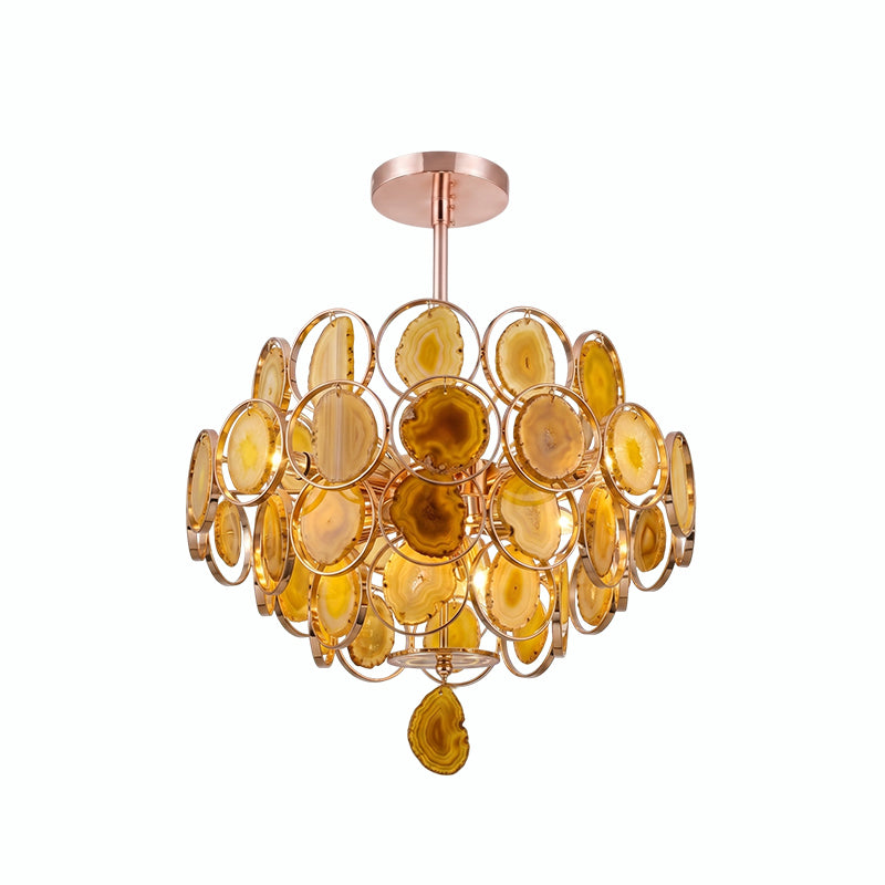 A Clérachic agate chandelier on white, its slices in warm amber and honey tones inside rose-gold rings.