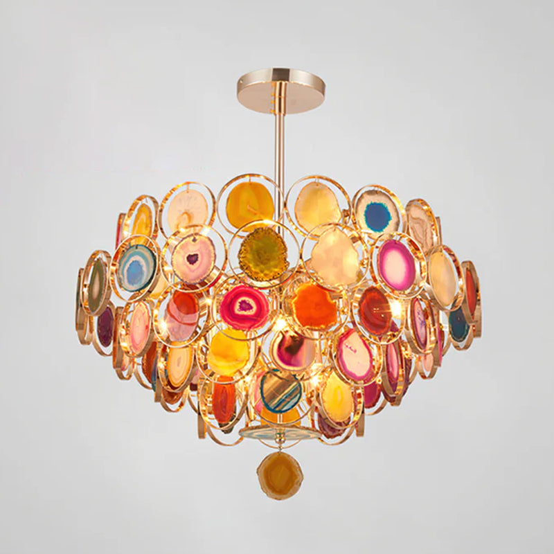 Multicolour Clérachic agate chandelier on a pale grey backdrop, showing red, amber, blue and pink slices lit from inside.